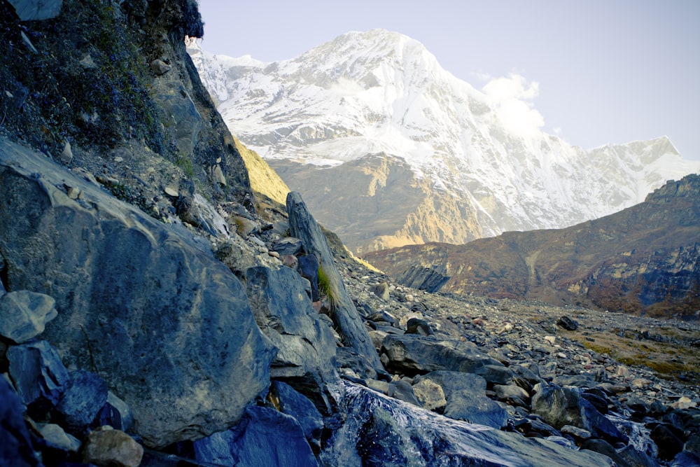 a rocky mountain with a snow capped mountain in the background