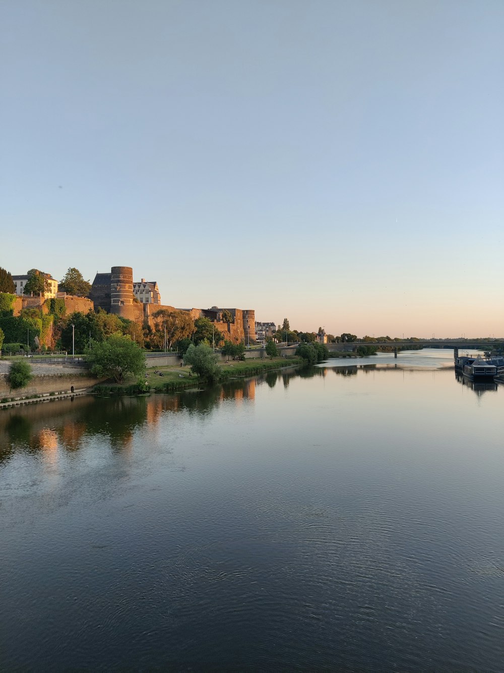 a body of water with a bridge in the background