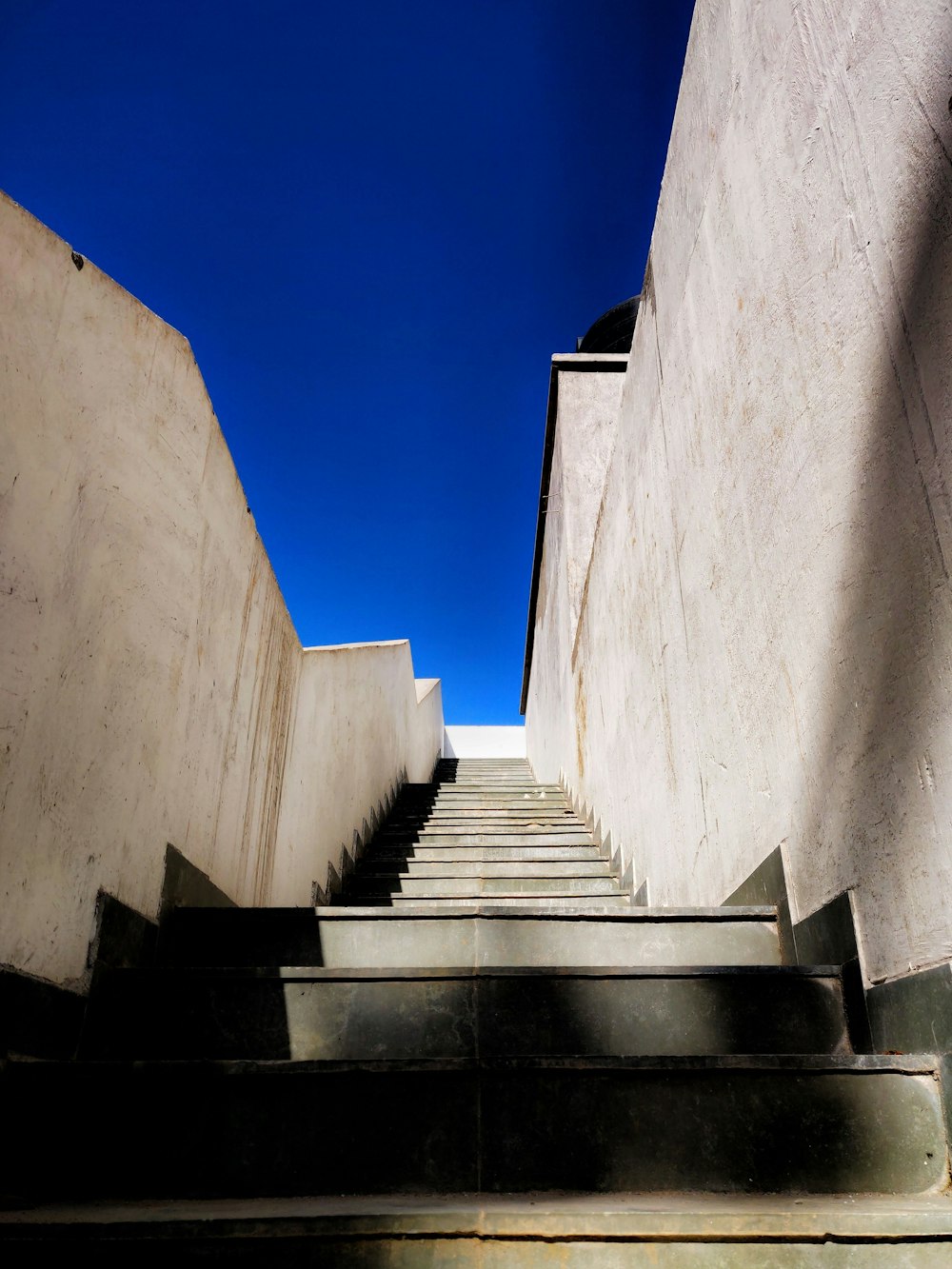 a set of stairs leading up to a blue sky