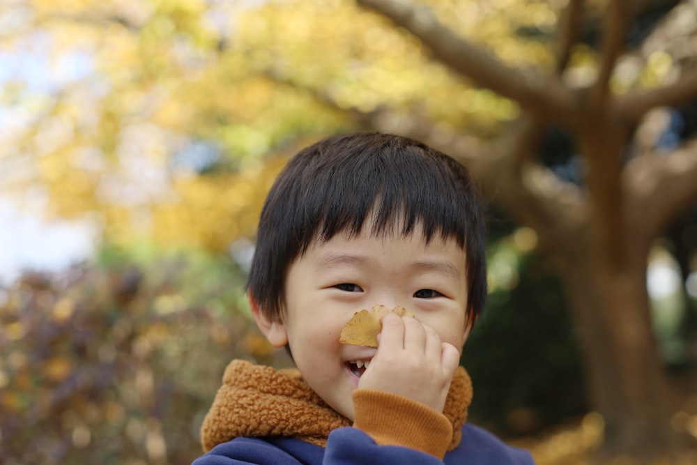 a young boy with a piece of food in his mouth