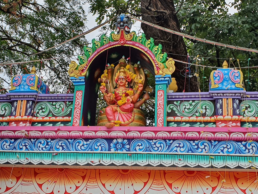 a statue of a hindu god on a colorful building
