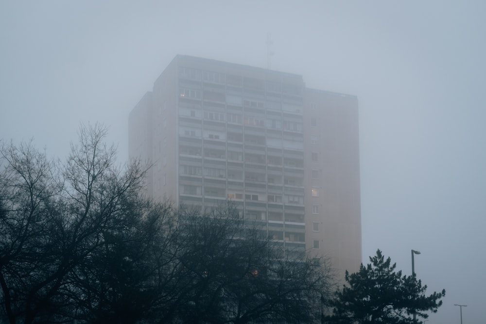 a very tall building in the middle of a foggy day
