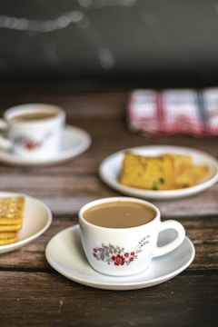 a table topped with plates of food and cups of coffee