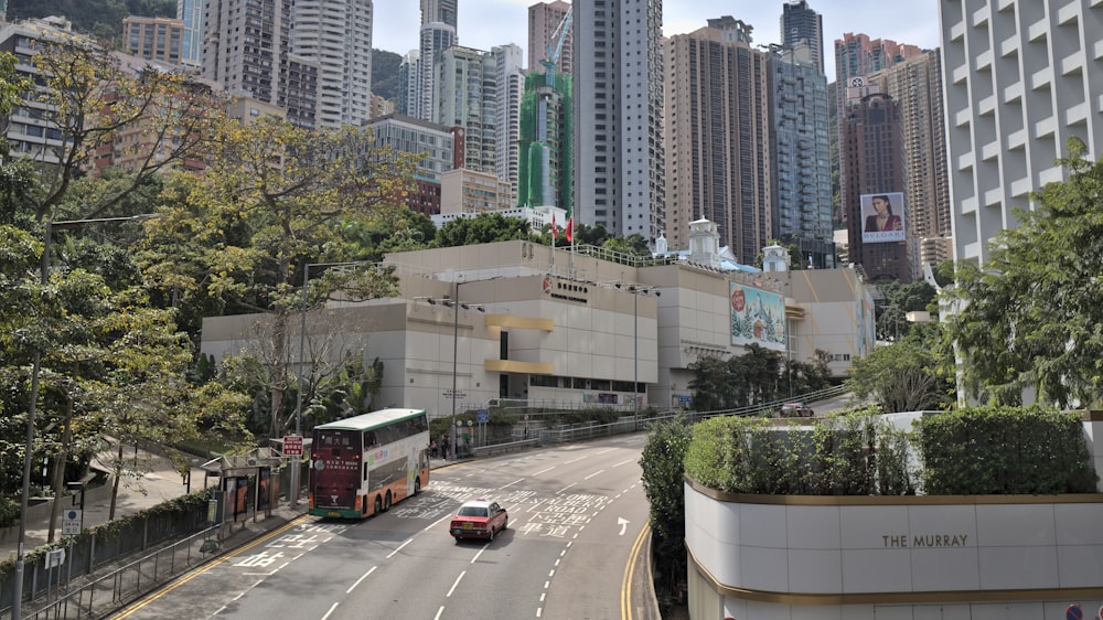 a bus driving down a street next to tall buildings