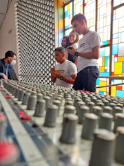 A group of musicians collaborating around a mixing console.