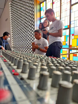 A group of musicians collaborating around a mixing console.