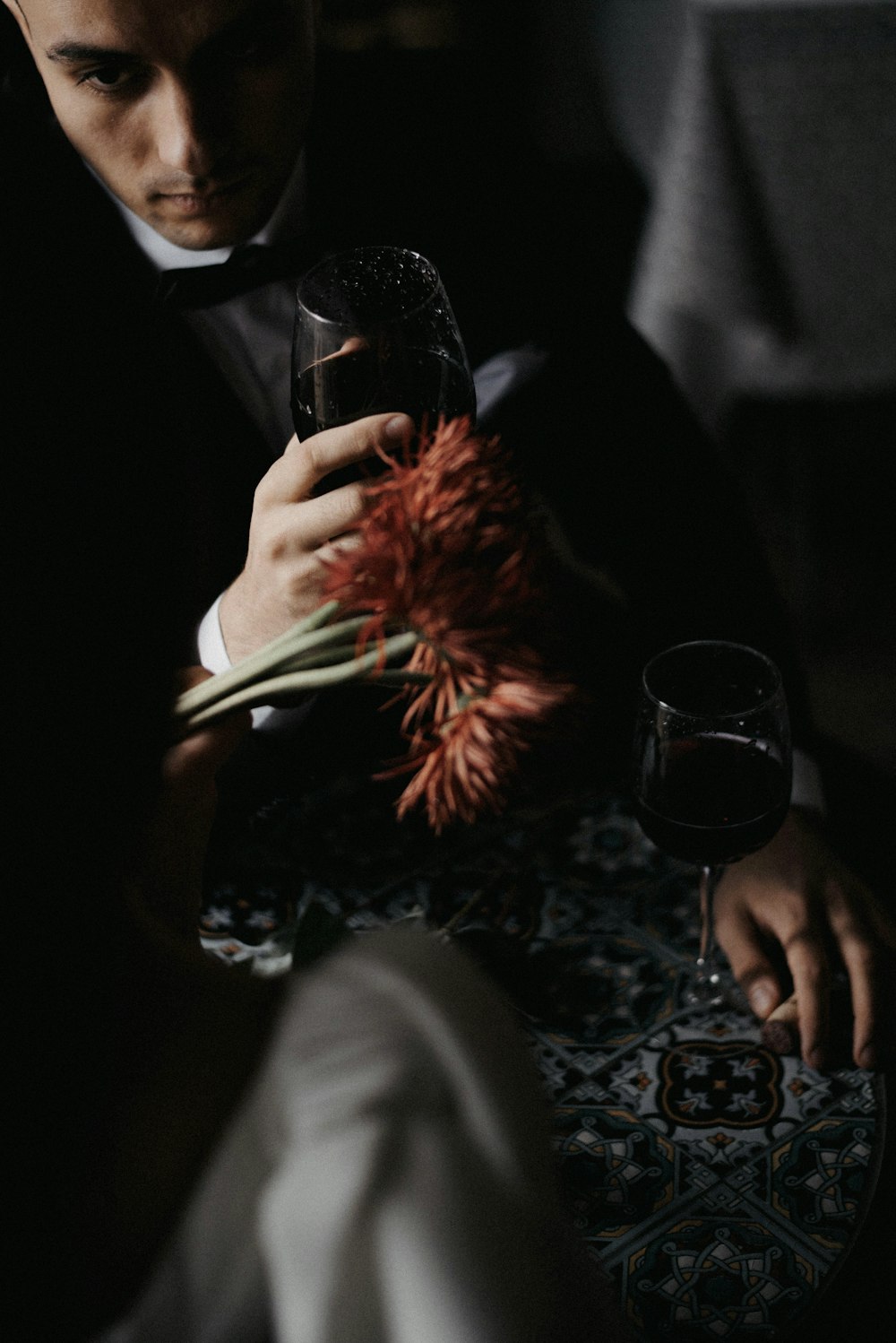 a man sitting at a table holding a wine glass