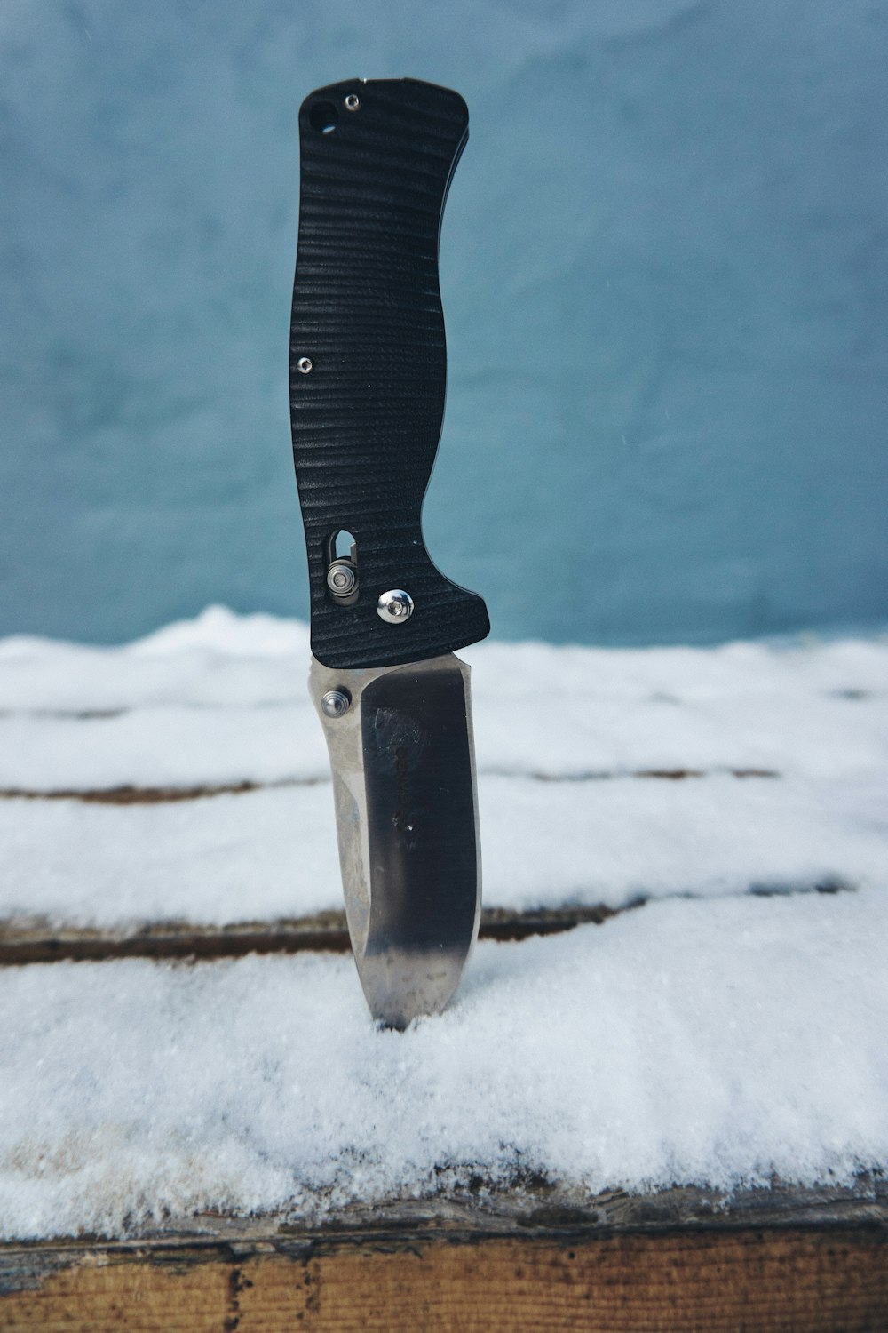 a knife sticking out of the snow on top of a table