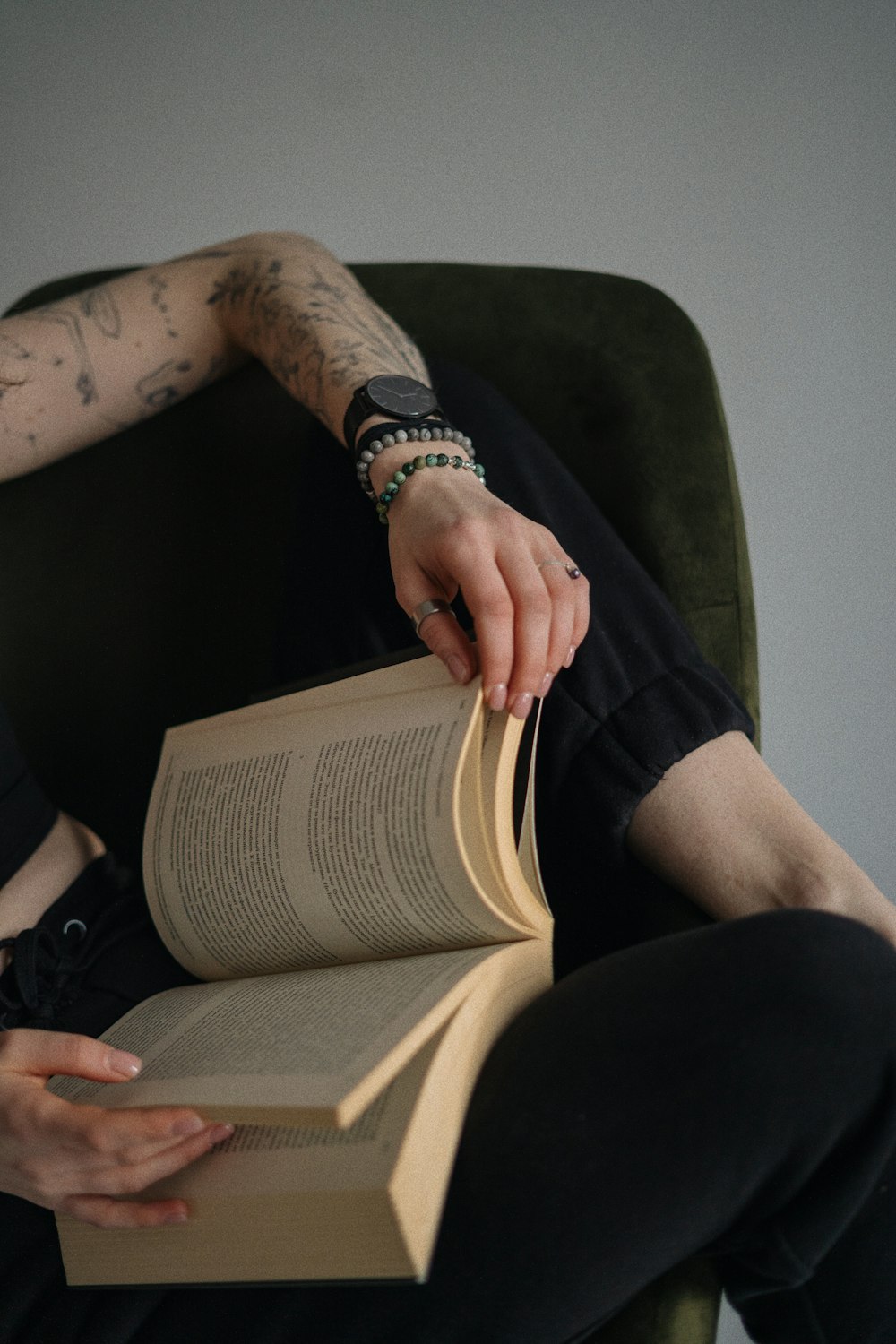 a person sitting in a chair holding a book