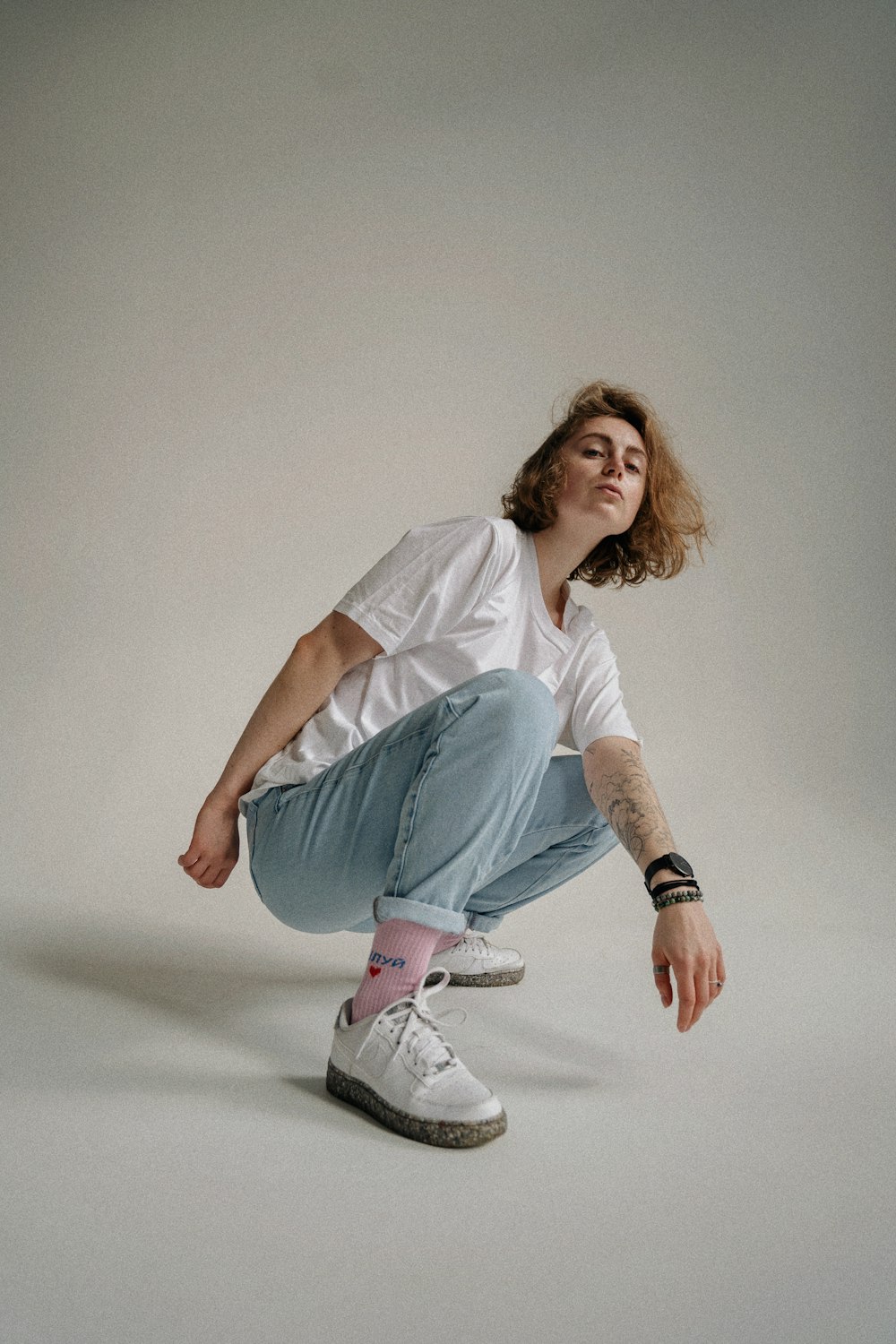 a man sitting on top of a skateboard on a white floor