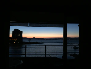 Balcony view at sunset with mountain peaks in the distance.