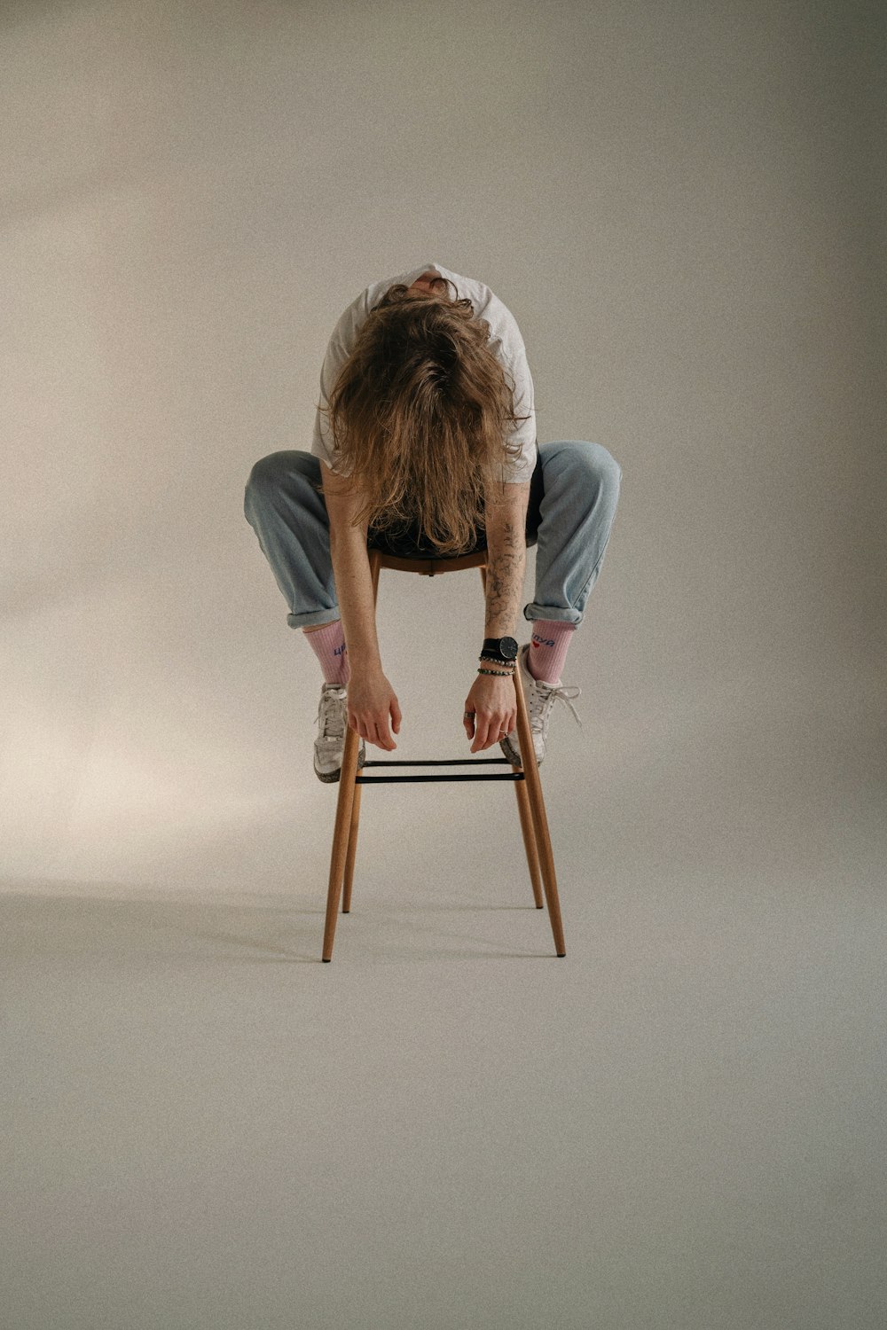 a man sitting on top of a wooden chair