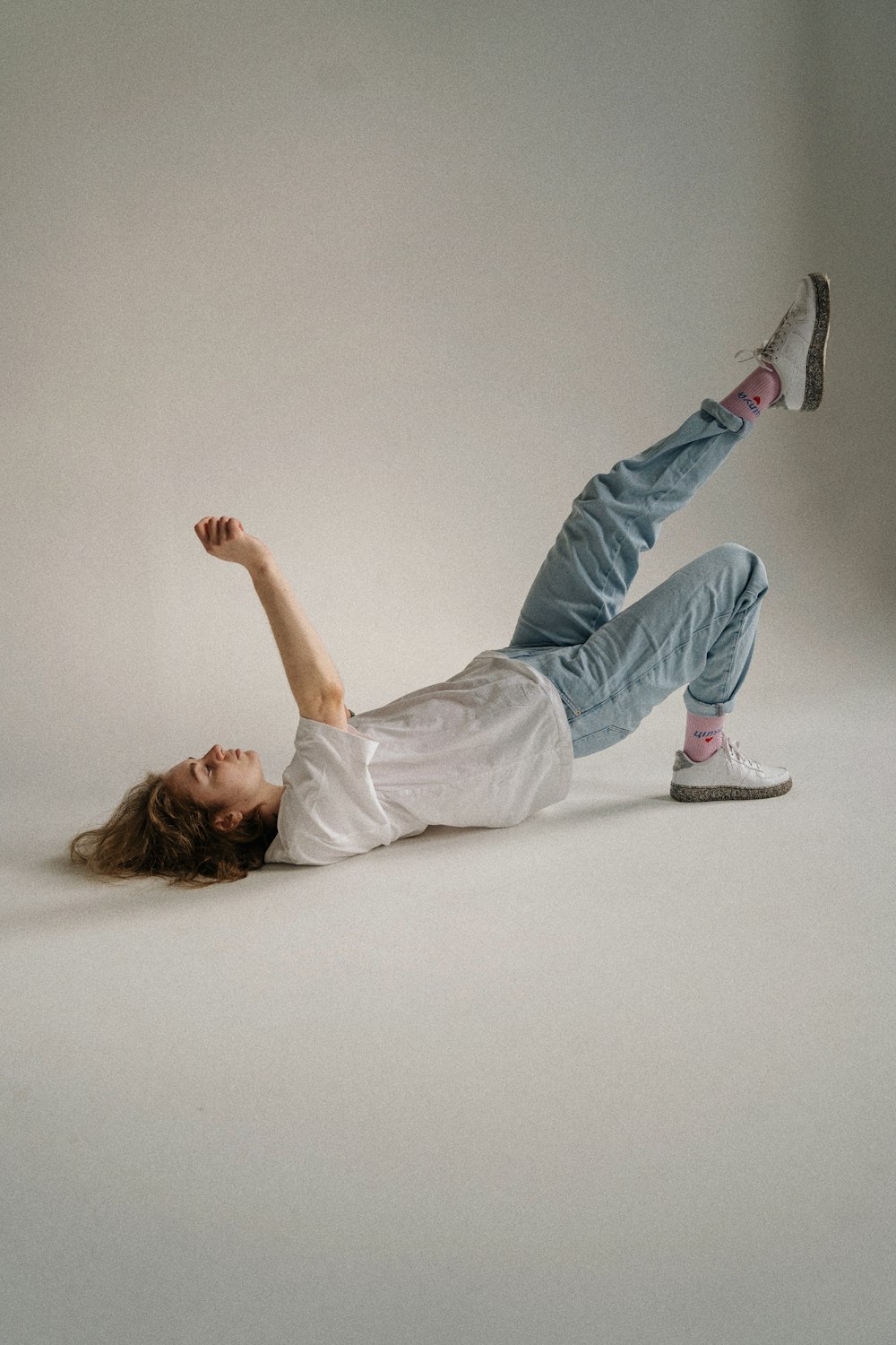 a person laying on the ground with their arms in the air