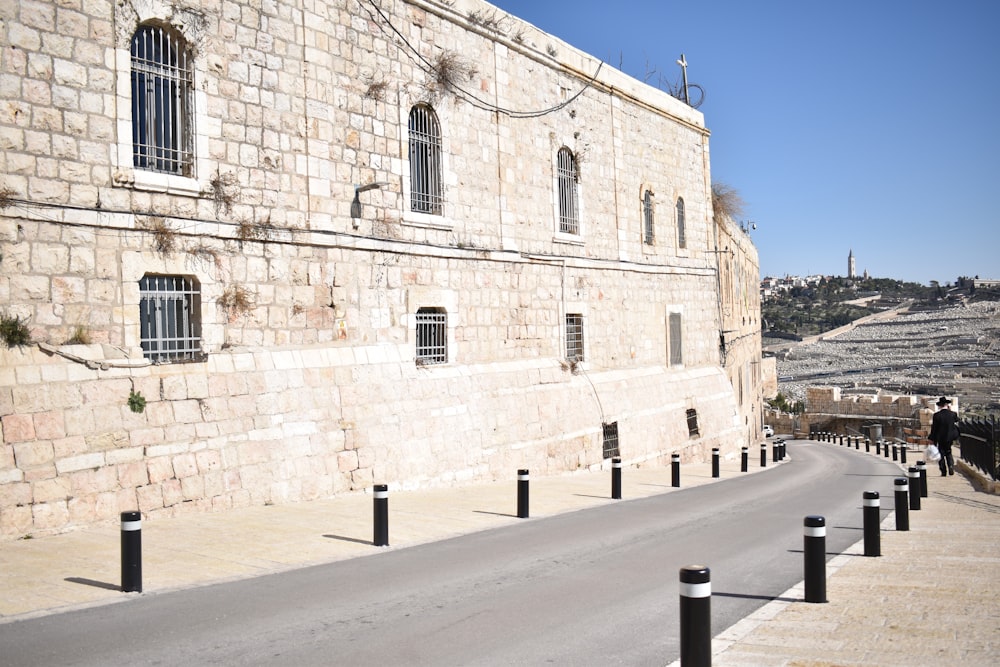 an empty street in front of a stone building