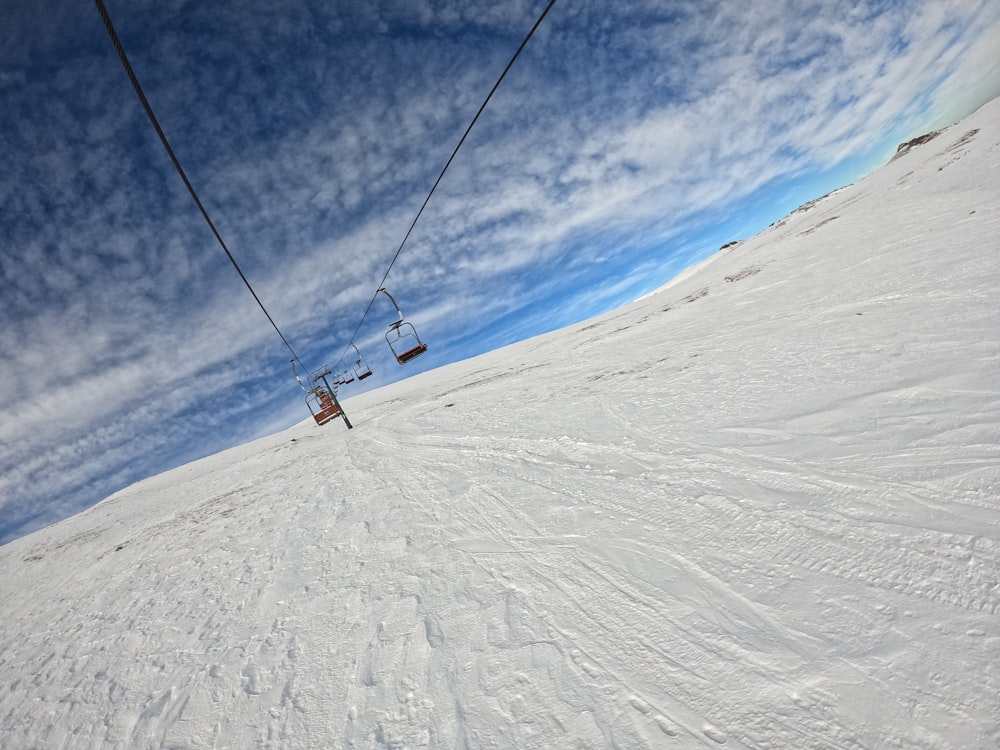 a ski lift going up a snowy hill