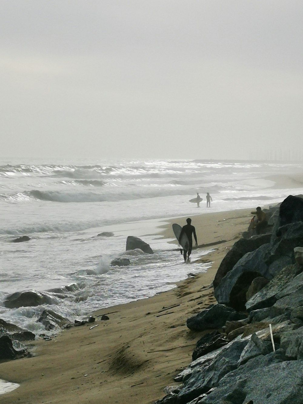 a person walking on a beach with a surfboard