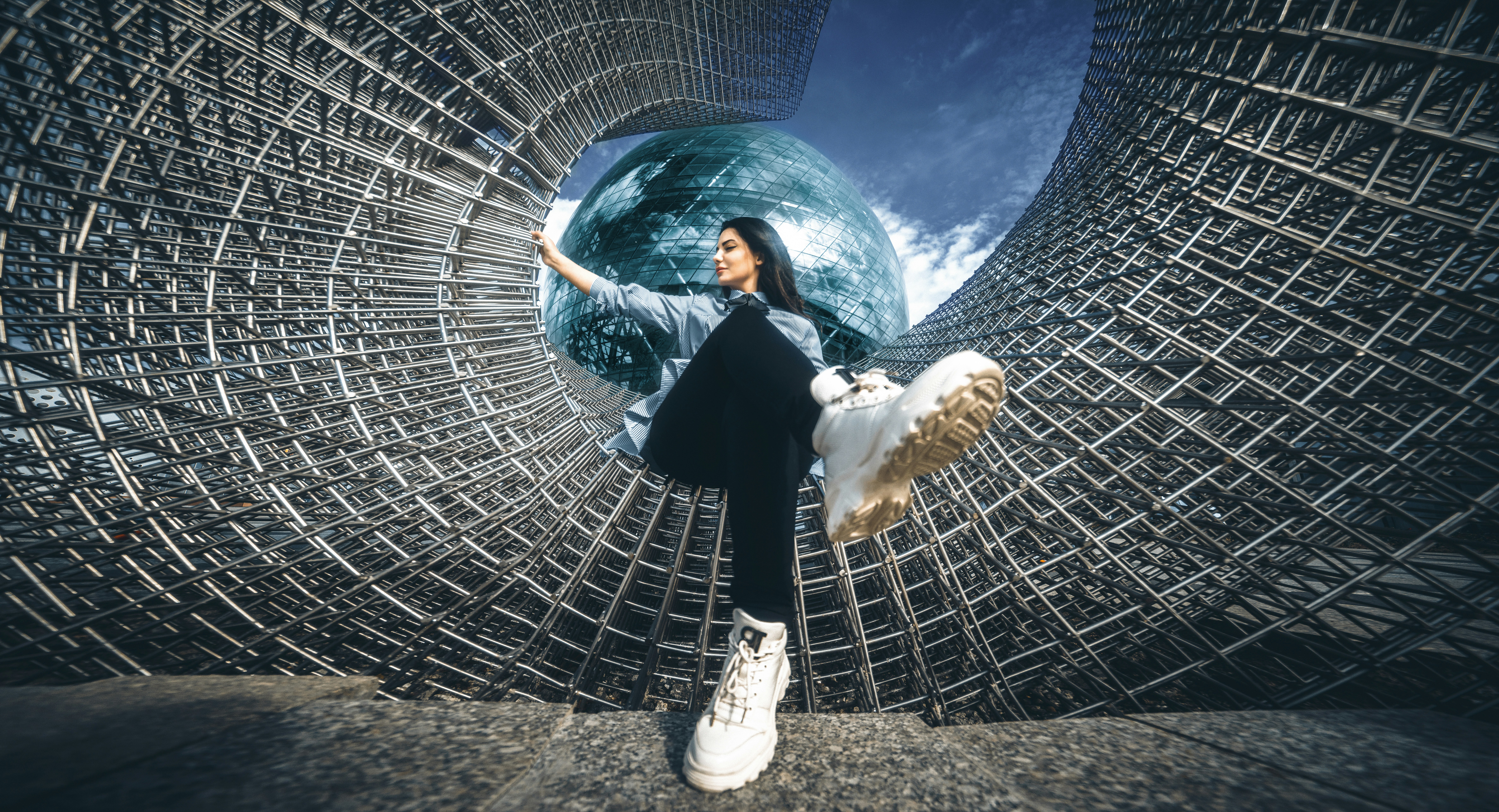 Una donna in piedi di fronte a una struttura metallica