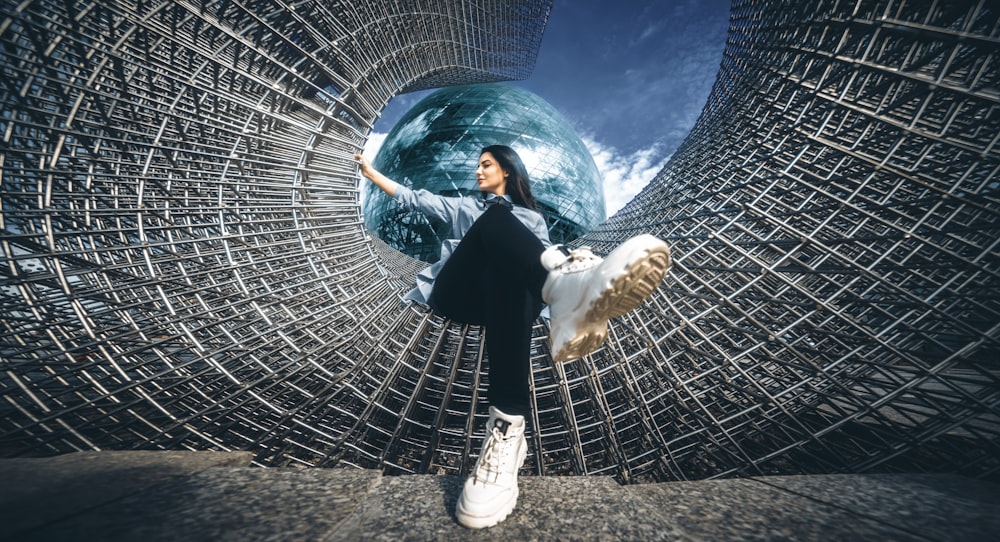 a woman standing in front of a metal structure