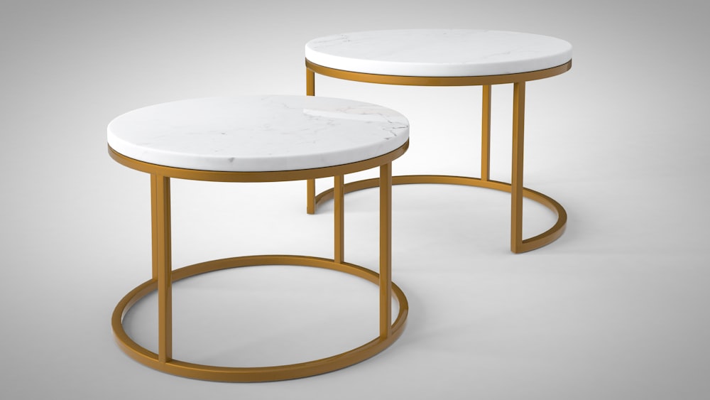 a pair of tables with marble top and gold legs