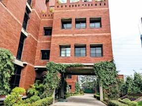 A warm, inviting photo of a friendly housing office entrance with greenery.