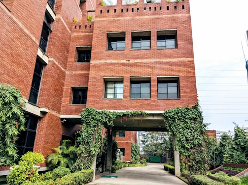 A warm, inviting photo of a friendly housing office entrance with greenery.