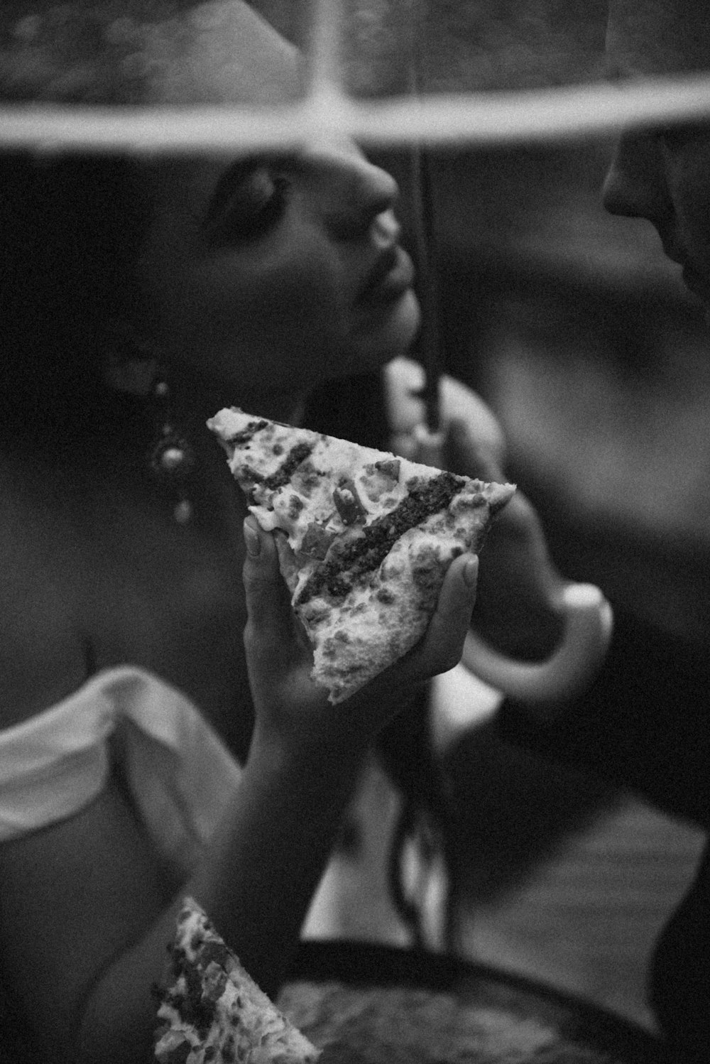 a young girl eating a slice of pizza