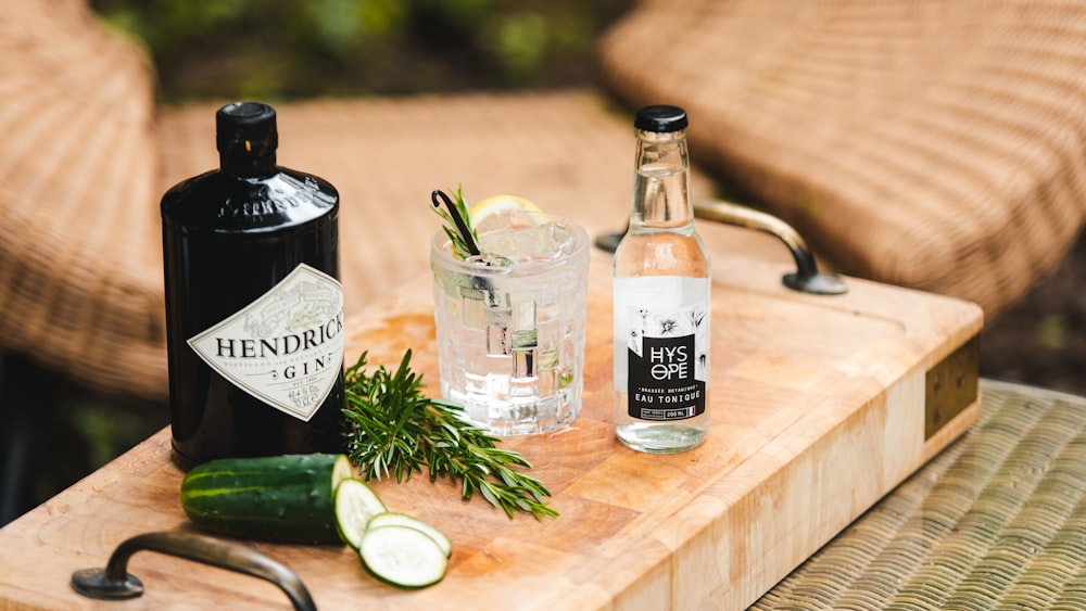 a wooden cutting board topped with bottles of alcohol