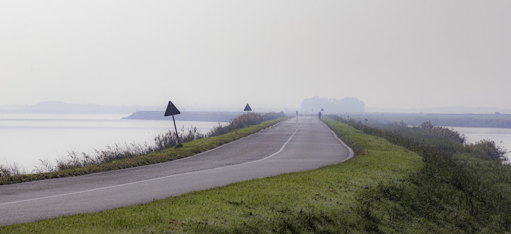 Una giornata nebbiosa su una strada di campagna vicino a uno specchio d'acqua