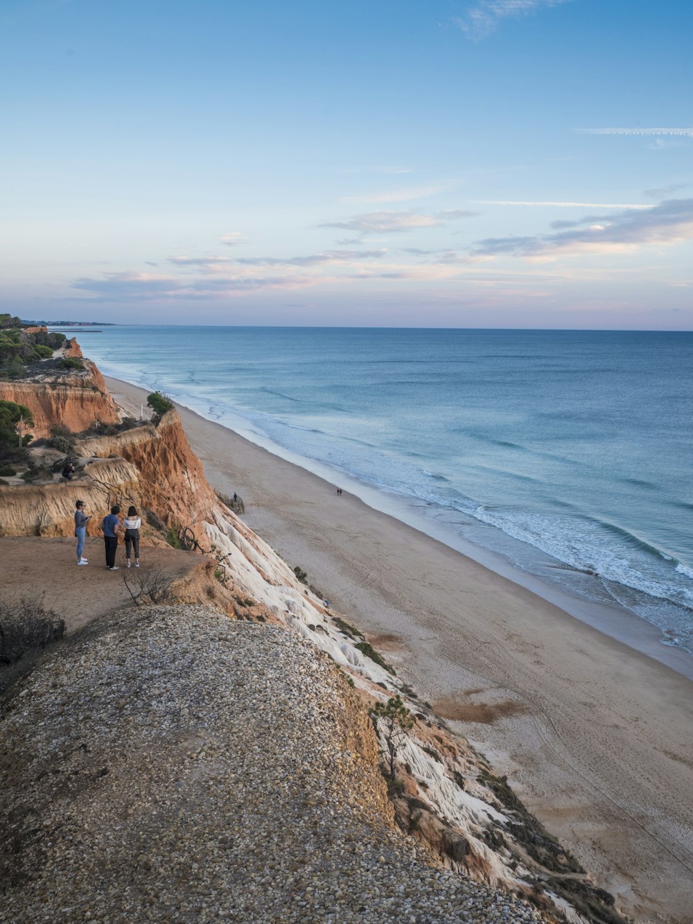 a group of people standing on top of a sandy beach