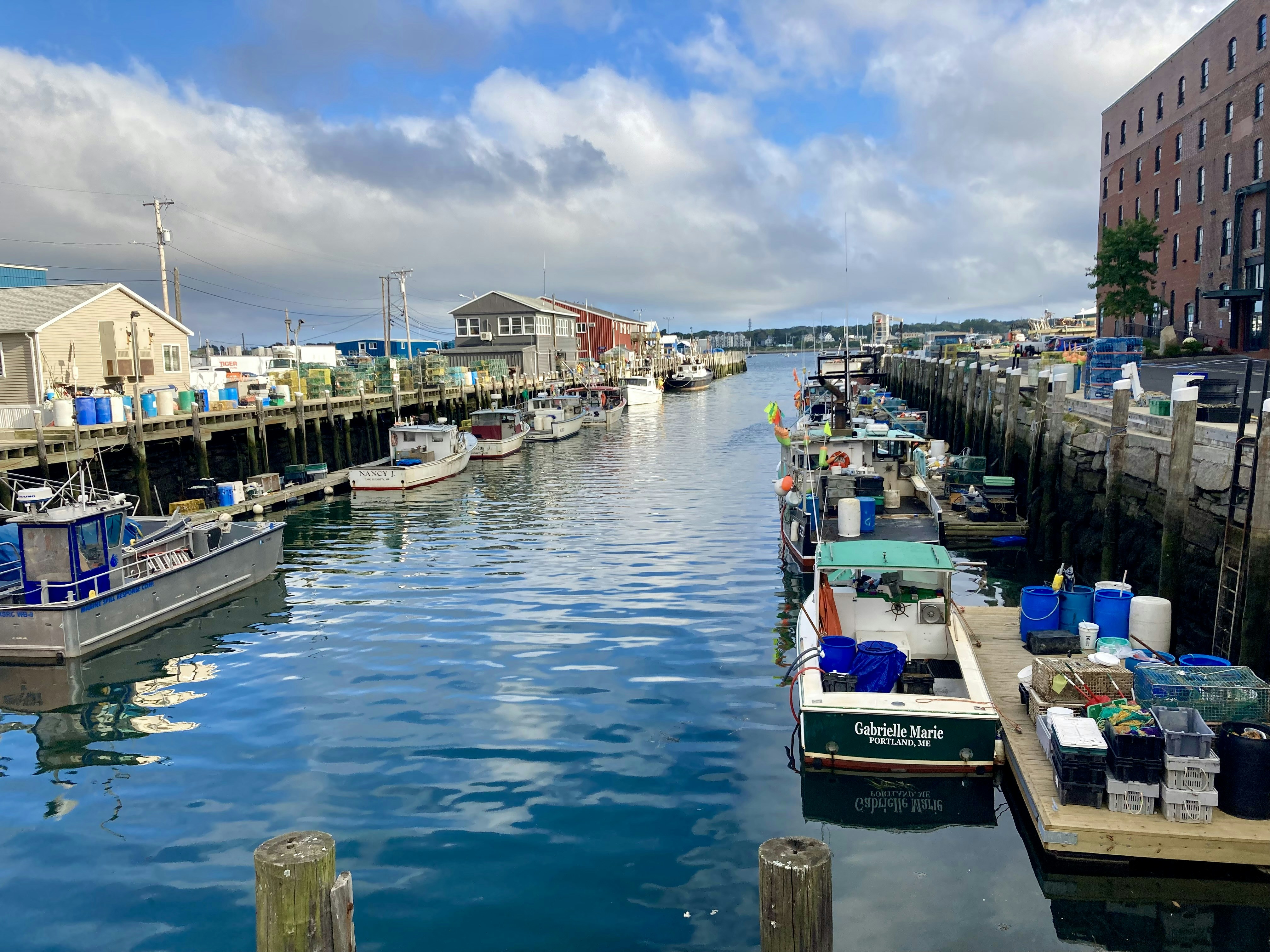 a harbor filled with lots of boats next to tall buildings, Harbor