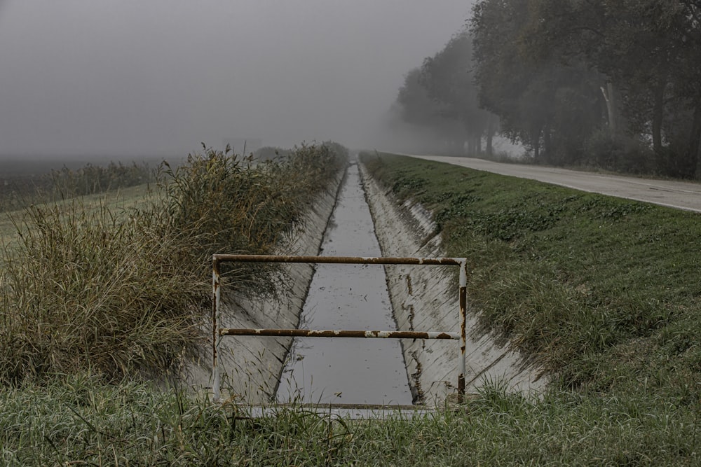 a flooded road with a gate in the middle of it