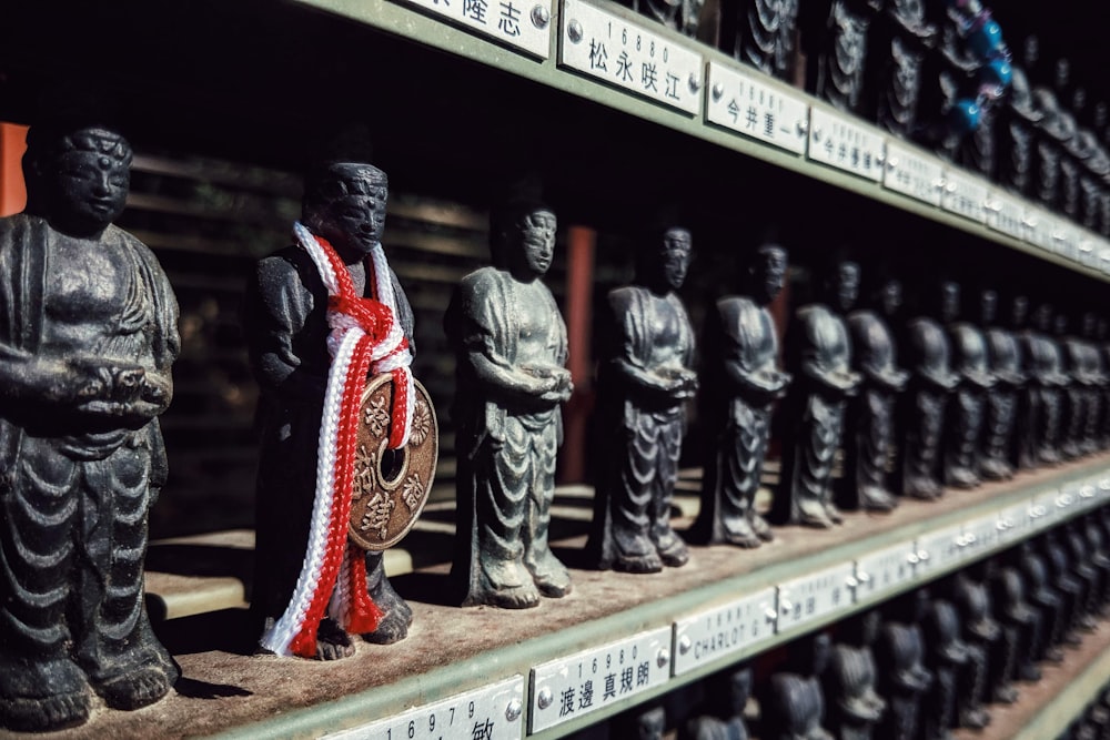 uma fileira de estátuas de Buda sentadas em cima de uma prateleira