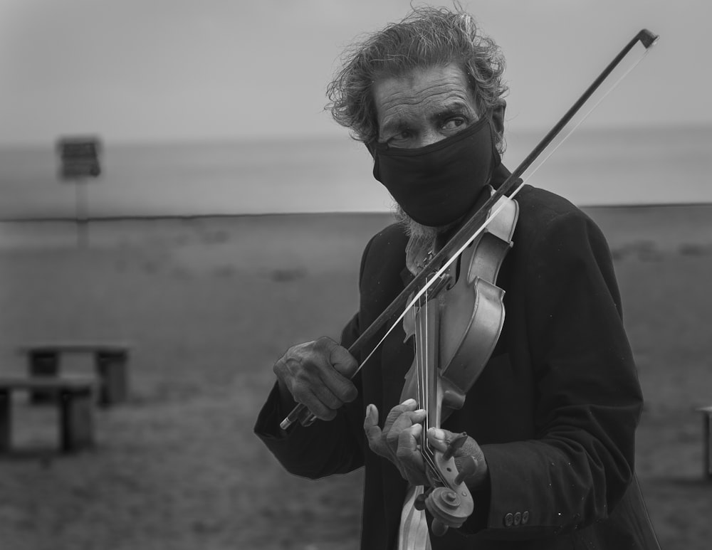 a woman wearing a mask and holding a violin