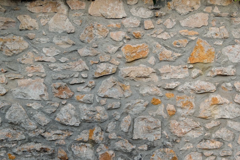 a stone wall with a clock on the side of it