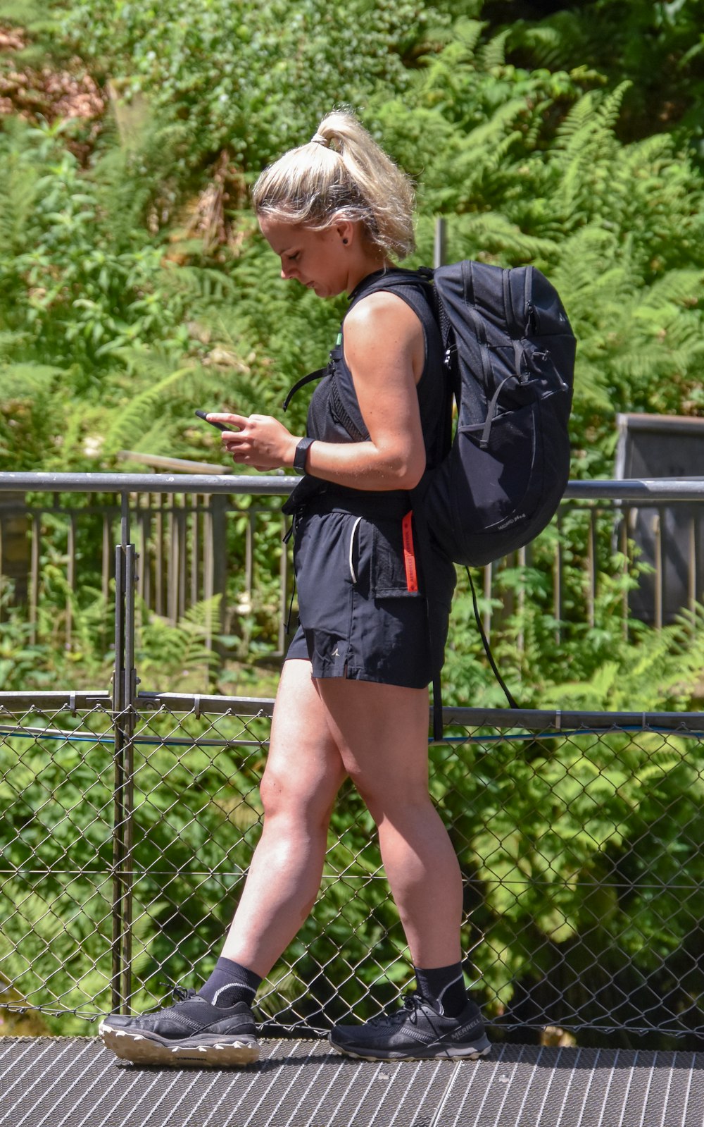 a woman with a backpack is walking on a bridge