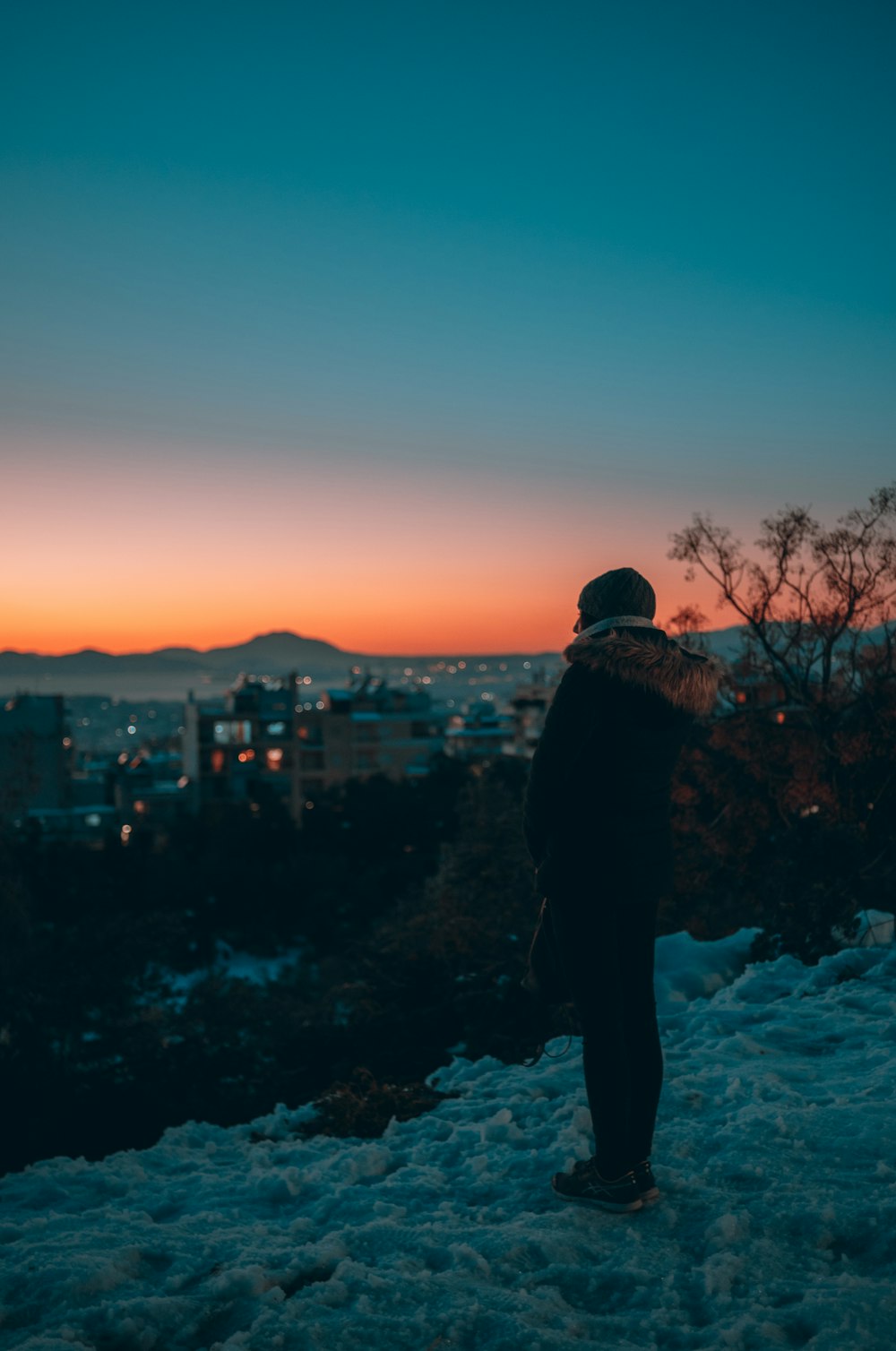 a person standing on top of a snow covered hill