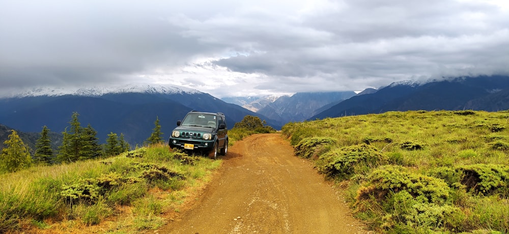 a jeep driving down a dirt road in the mountains