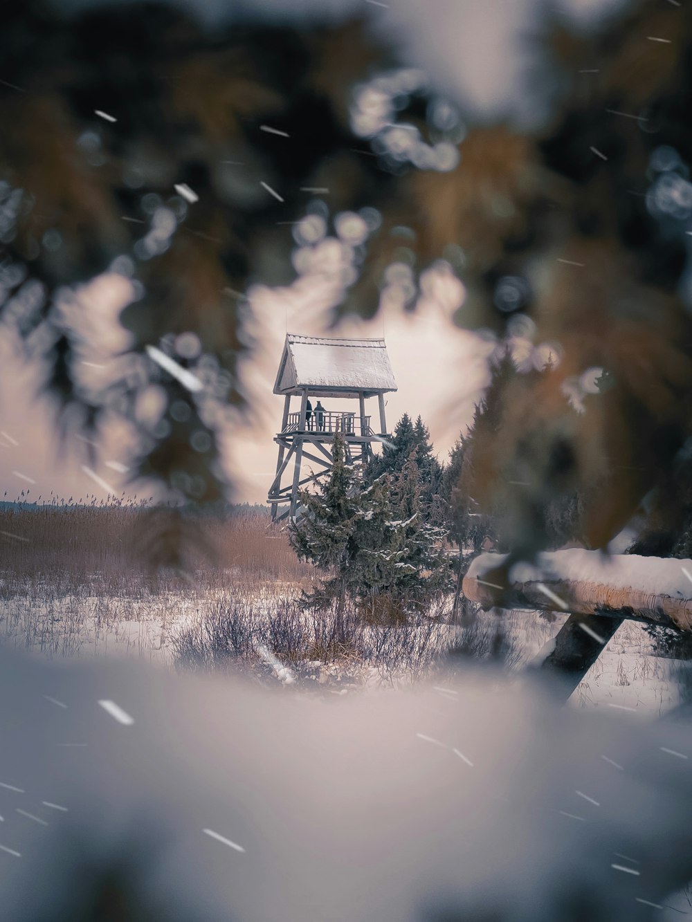 a small tower in the middle of a snowy field