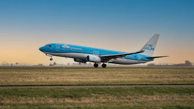 a blue and white airplane is on the runway