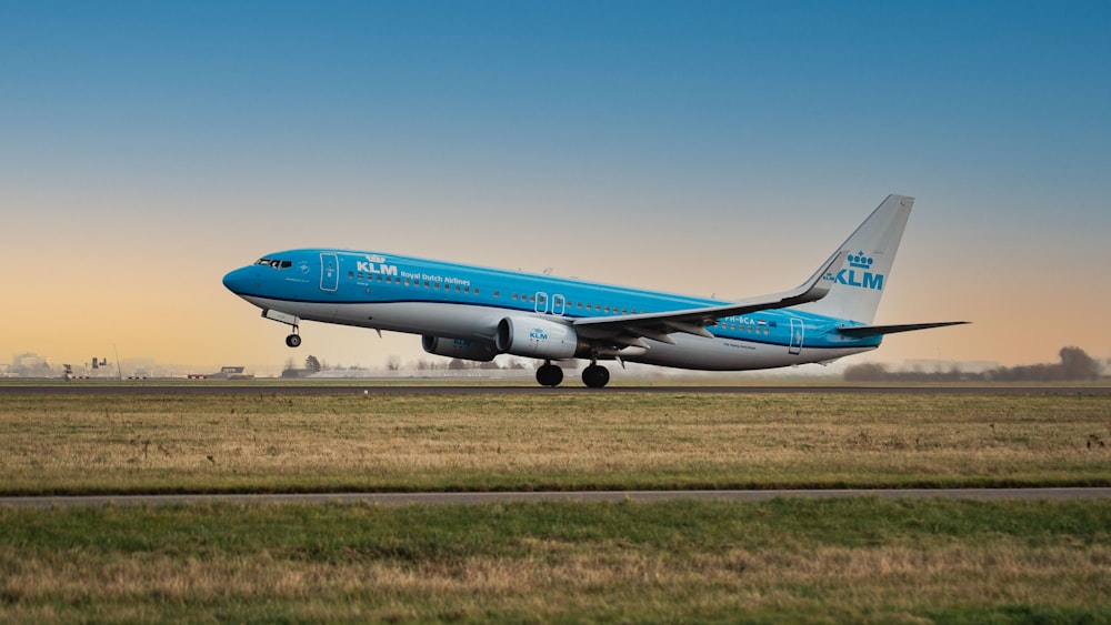 a blue and white airplane is on the runway