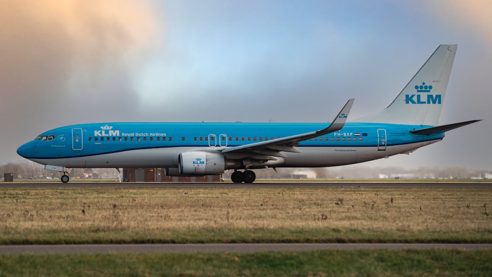 a blue and white airplane is on a runway