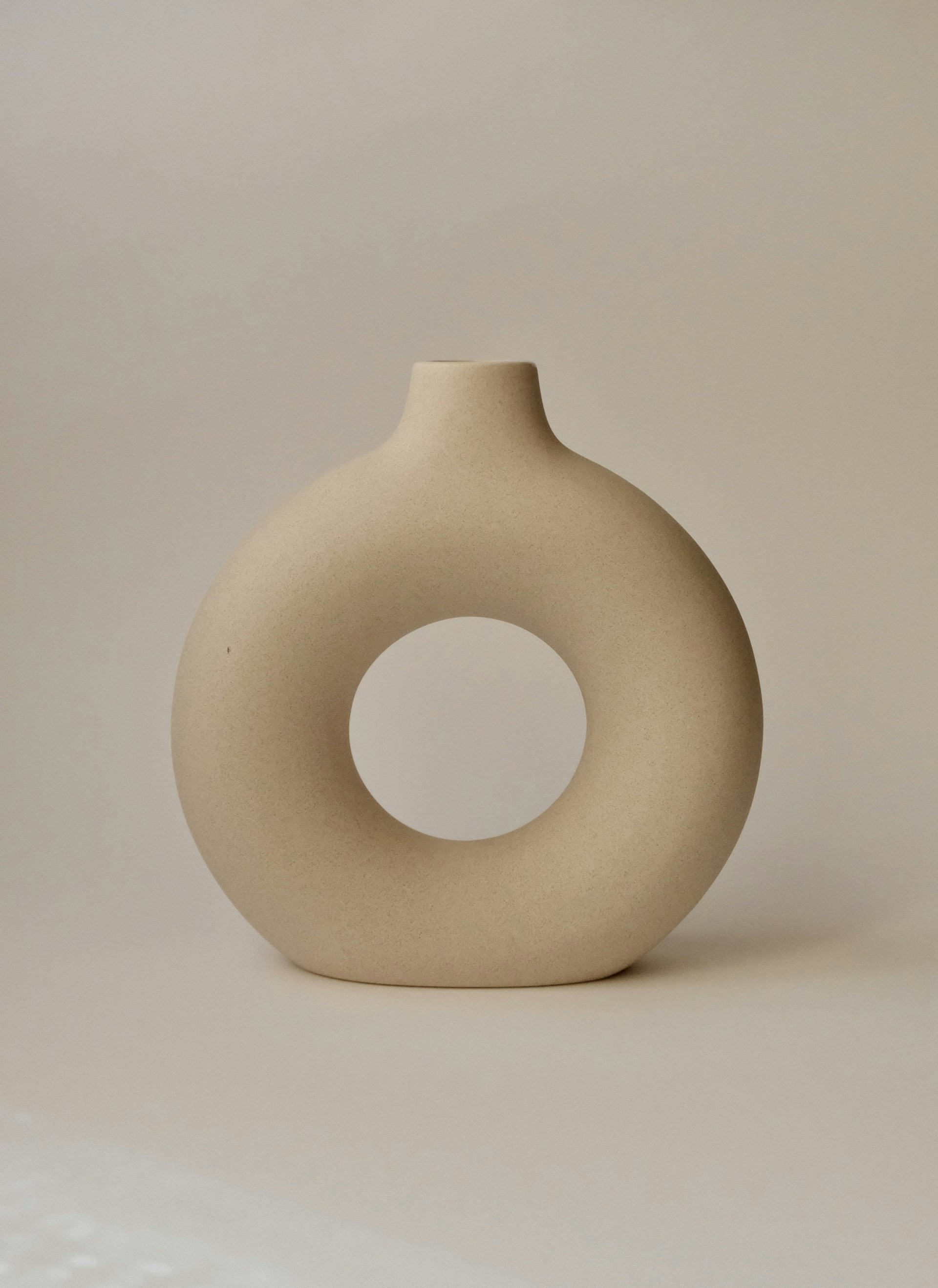 a white vase sitting on top of a table