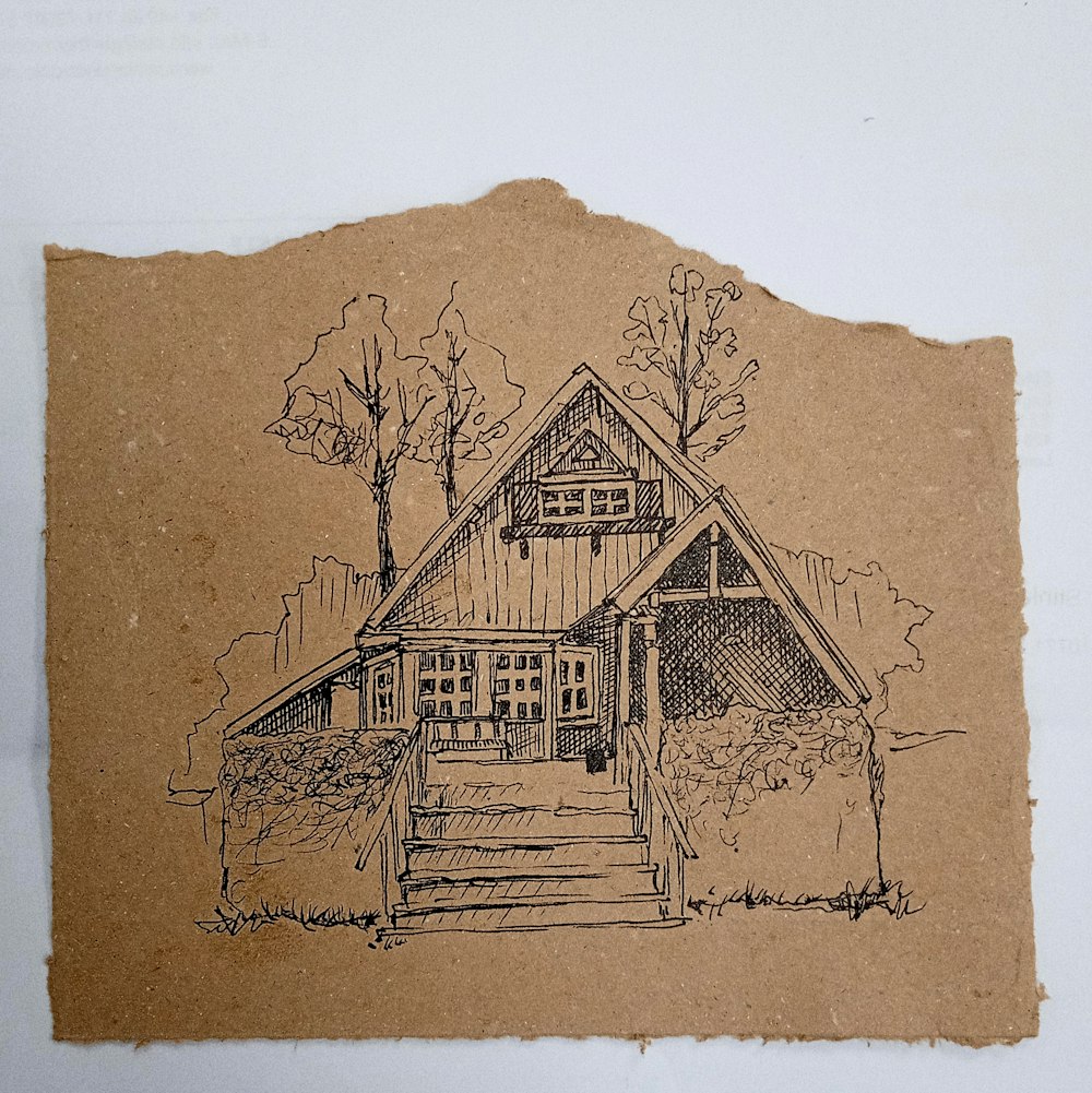 a drawing of a house on a piece of brown paper