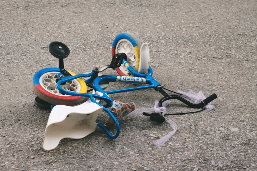 a broken toy bike laying on the ground