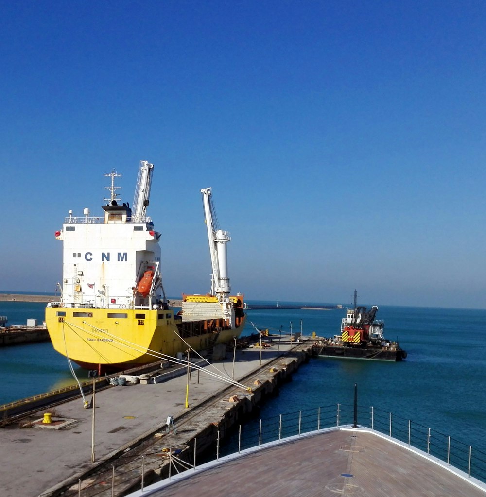 a large yellow and white boat docked at a pier