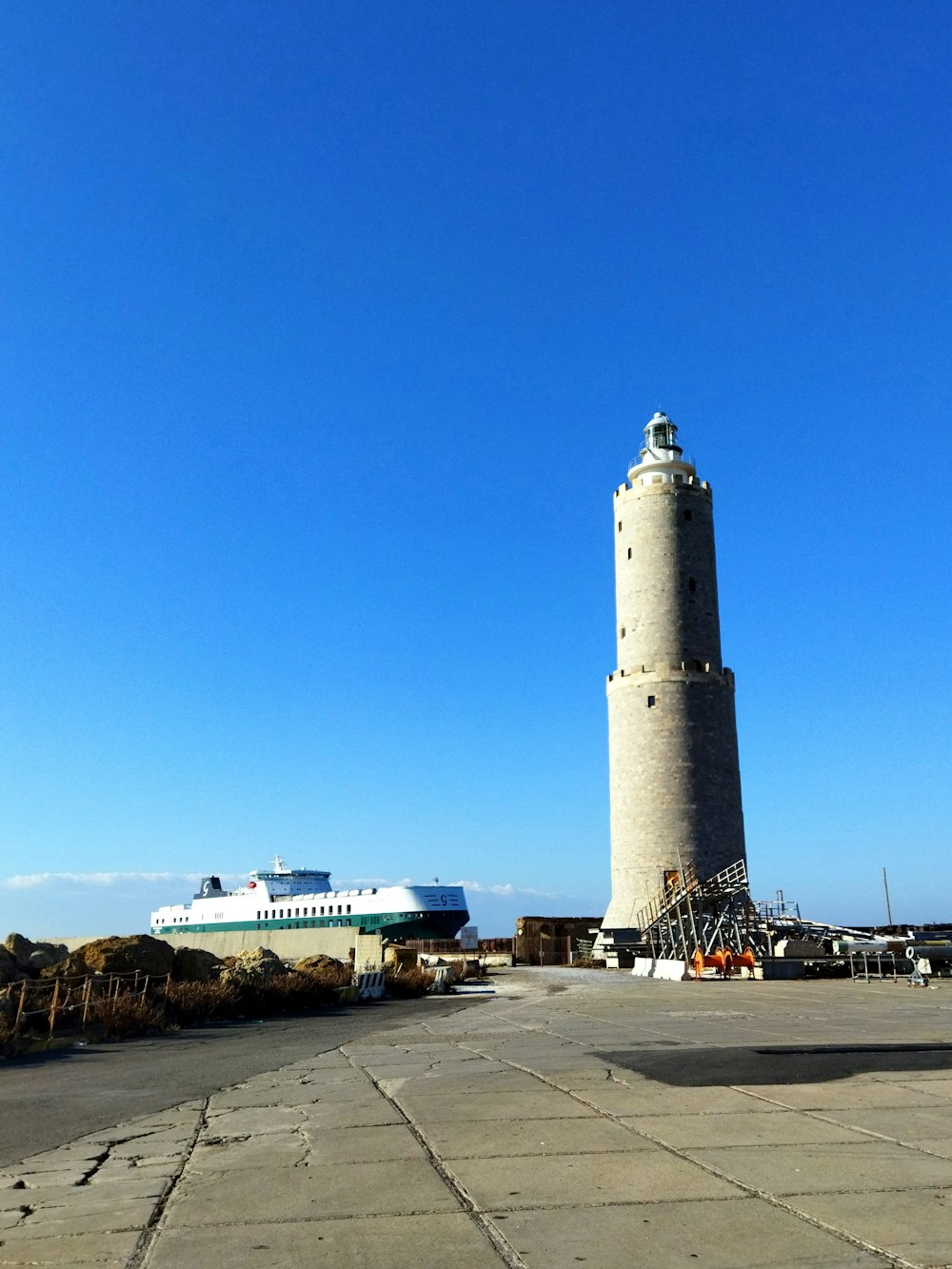 a large white lighthouse sitting on the side of a road