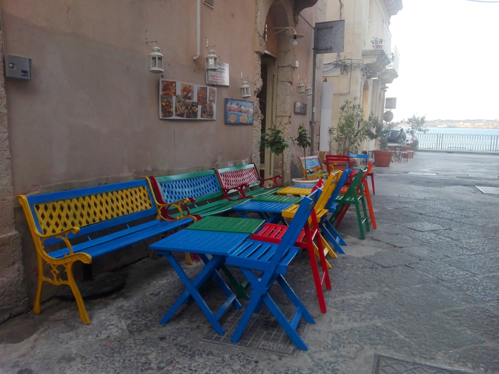 a row of colorful benches sitting next to a building
