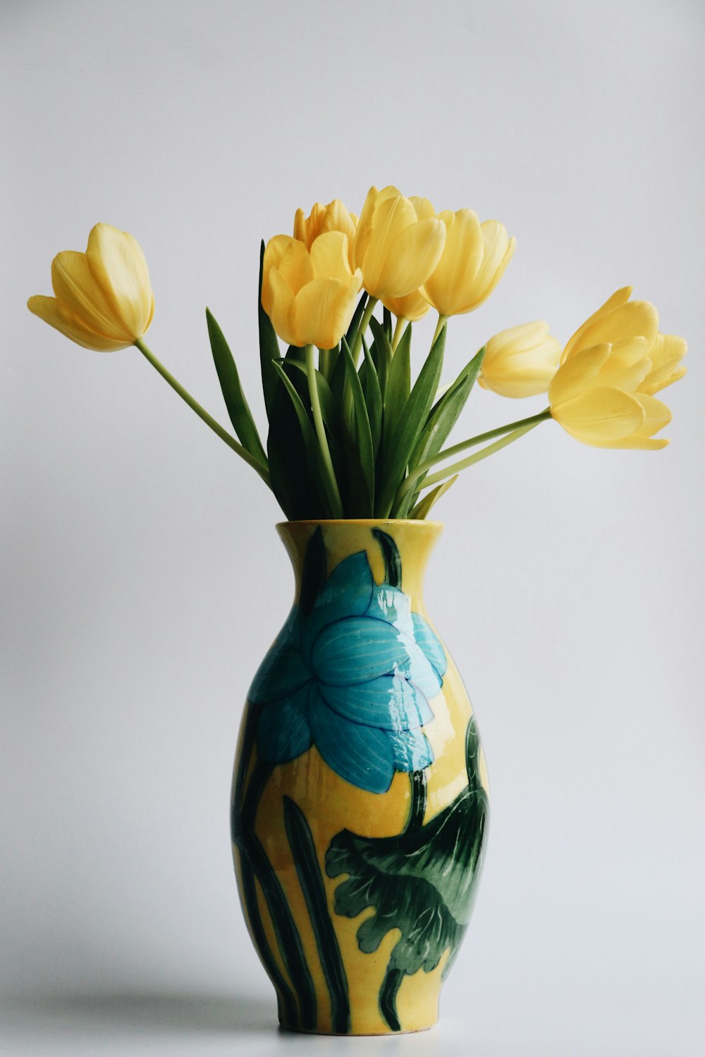 a vase filled with yellow flowers on top of a table