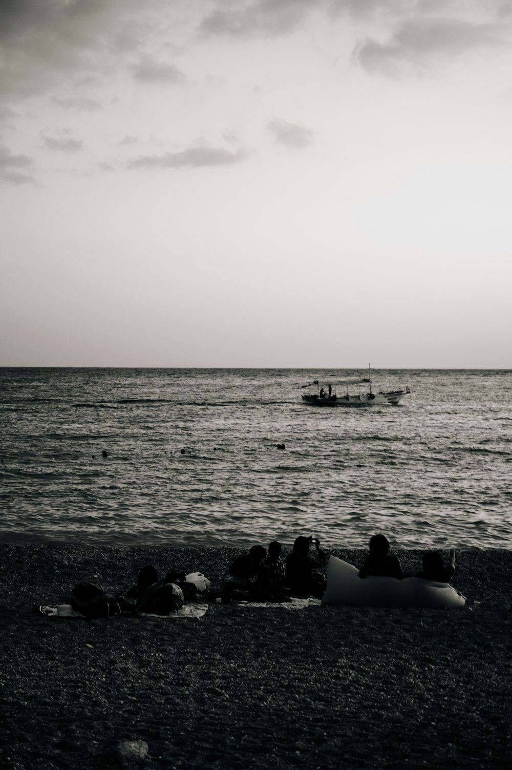 a group of people laying on top of a beach next to the ocean