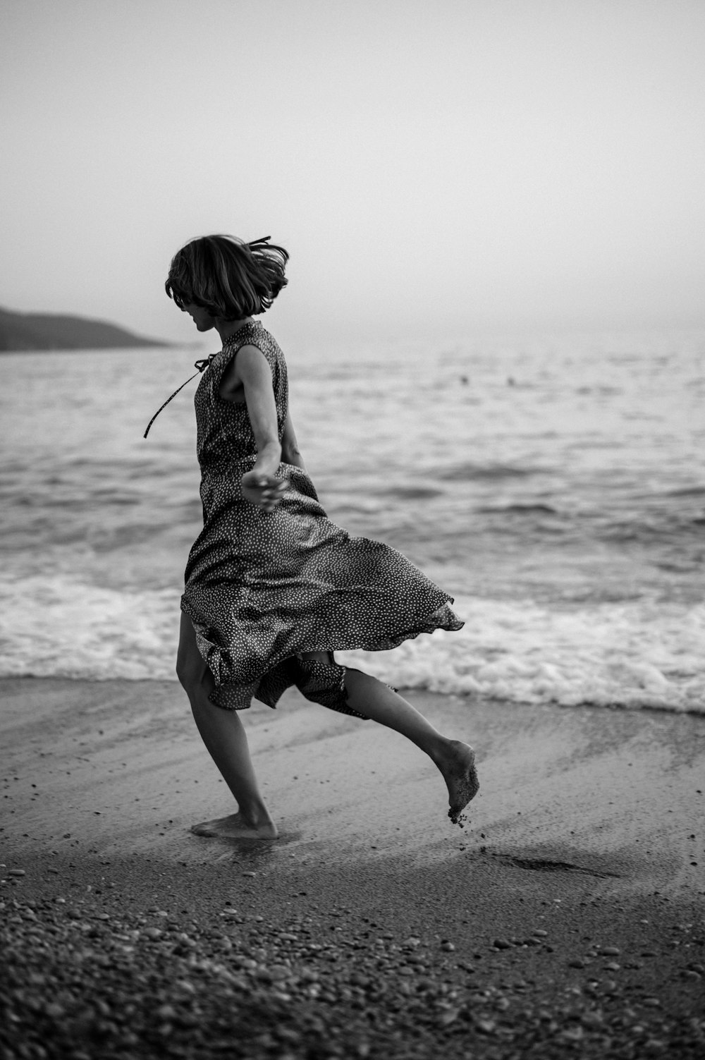 a young girl is running on the beach